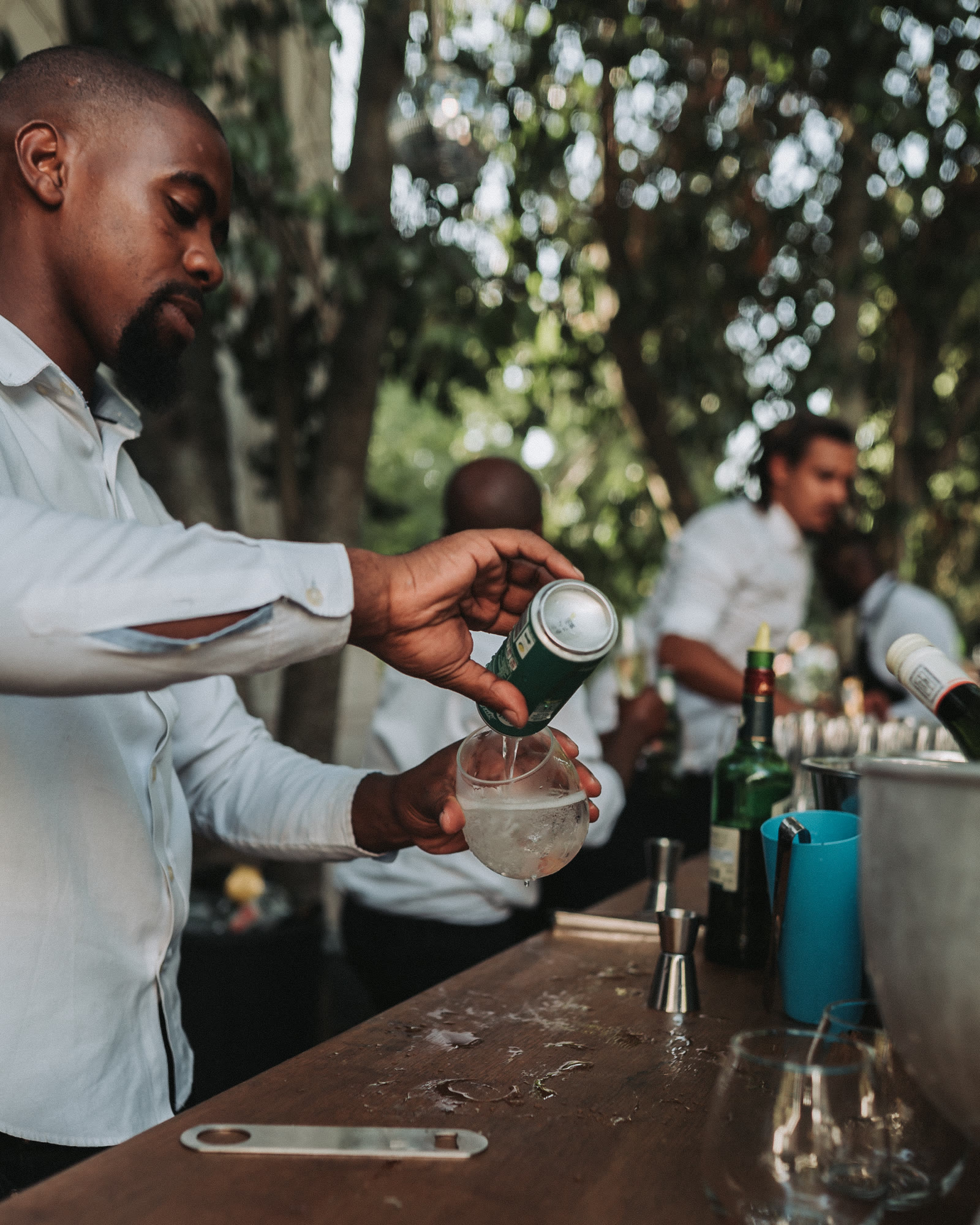 Bartender pouring a drink at an outdoor event bar