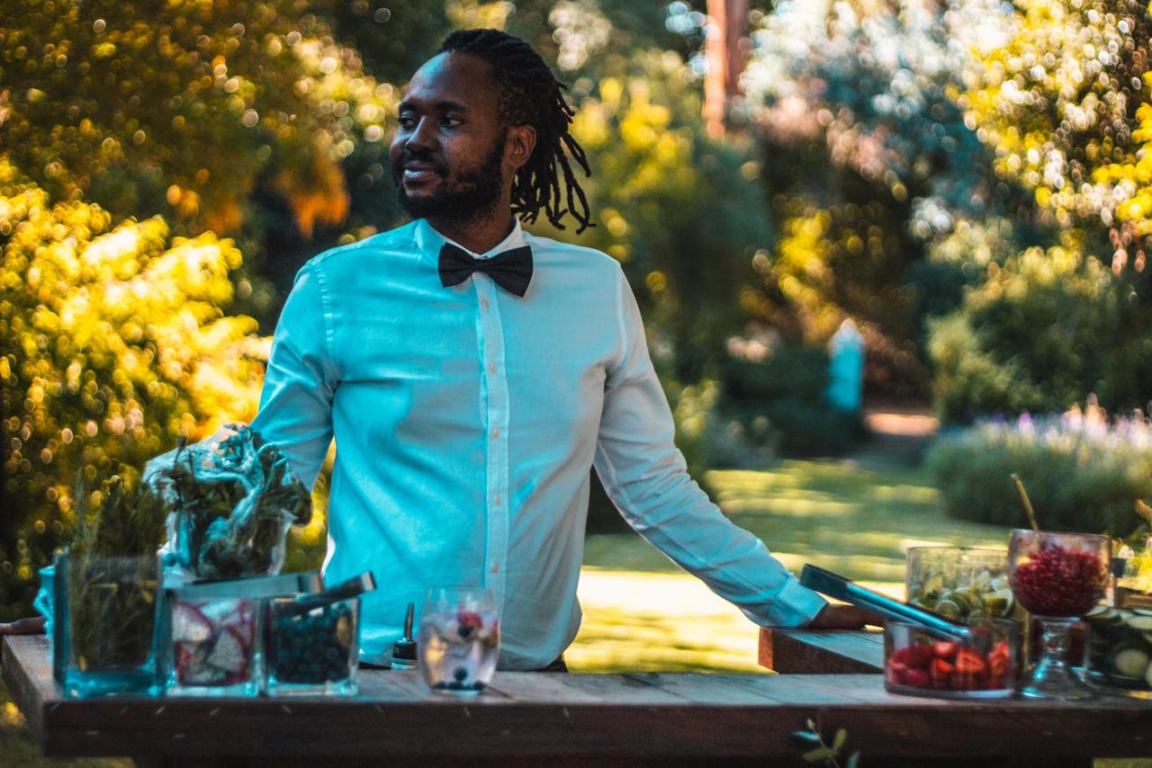 Bartender behind a garden cocktail bar with fresh garnishes