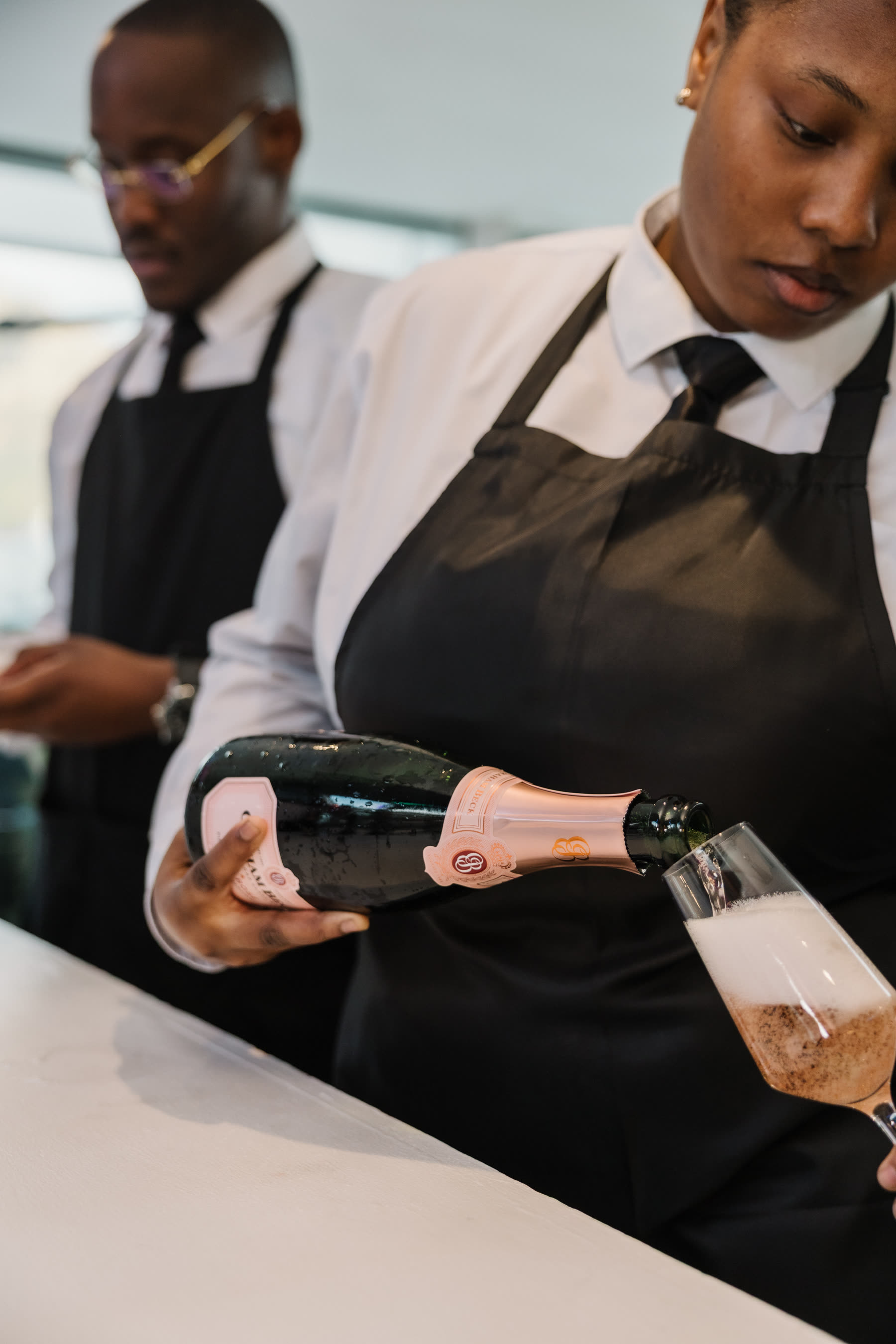 Waitron pouring sparkling wine into a flute