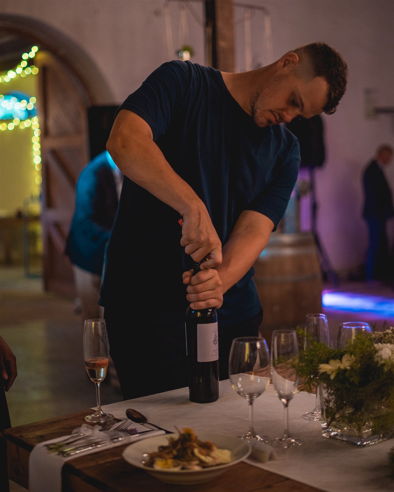 Jarryd le Roux opening wine on the floor at a Cape Town event